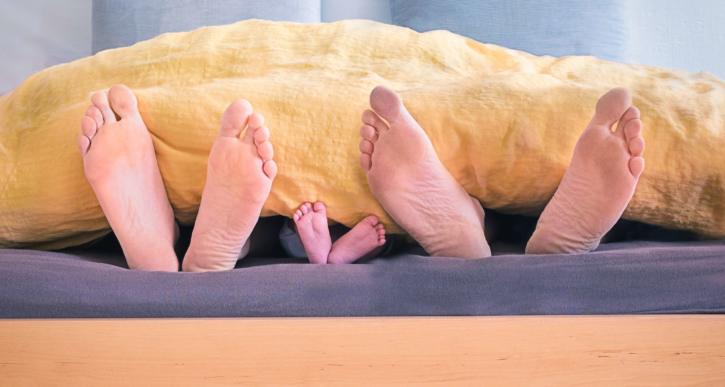 family-of-three-lying-on-bed-showing-feet-while-covered-with-1021051 ELTERN/KIND-BERATUNG